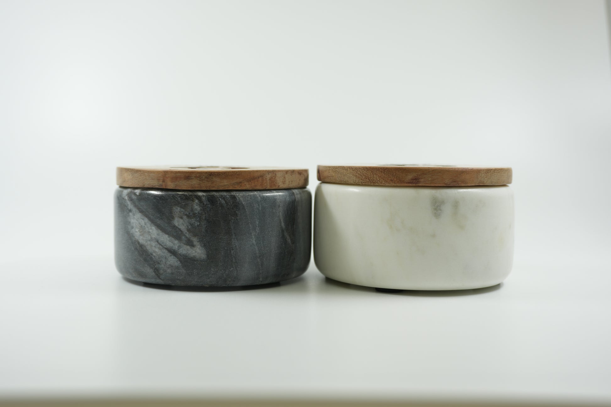 Side view black and white marble spice cellars with wooden lids by Casa de Abuela